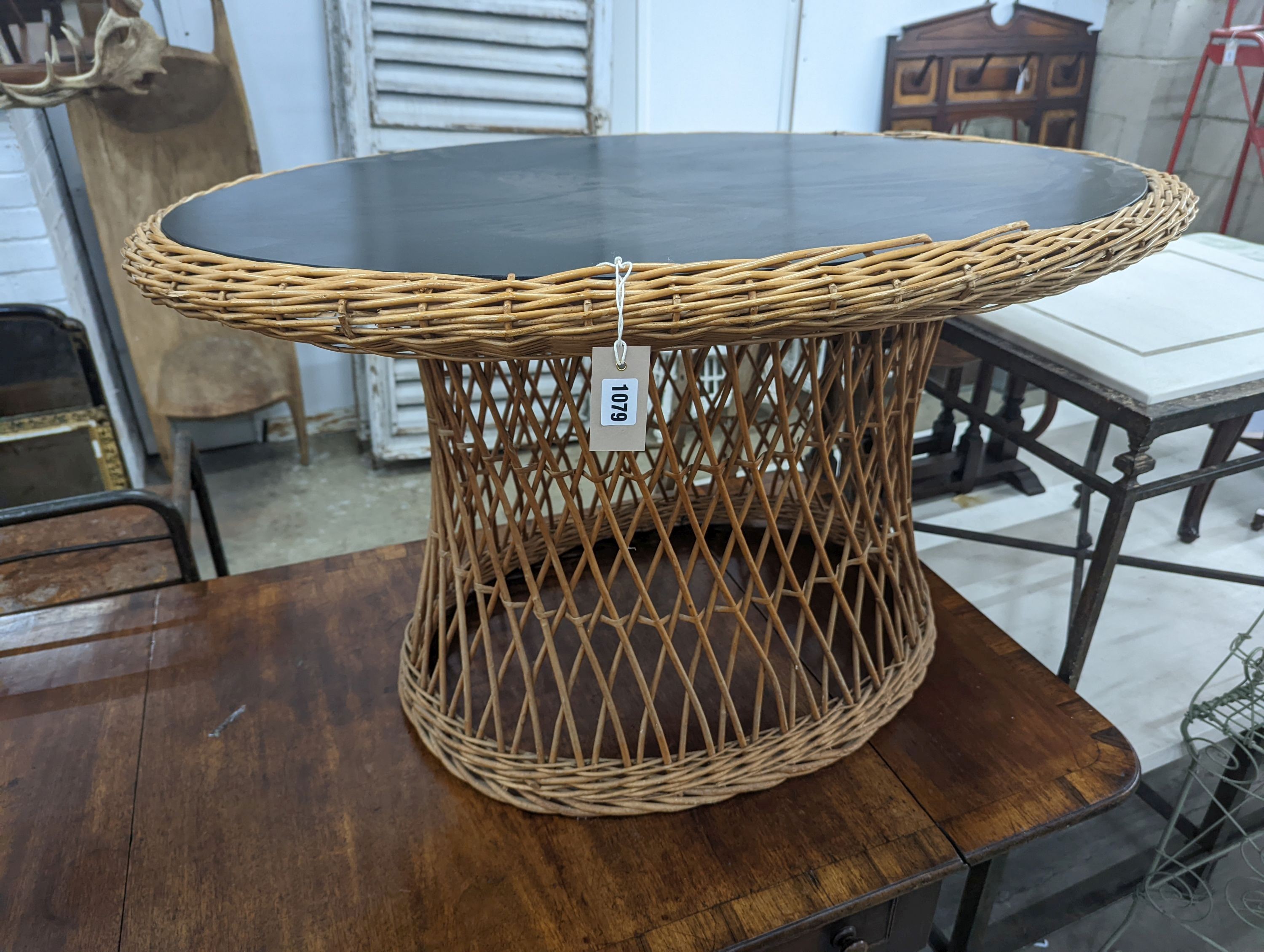 An oval rattan conservatory table, length 100cm, depth 71cm, height 60cm